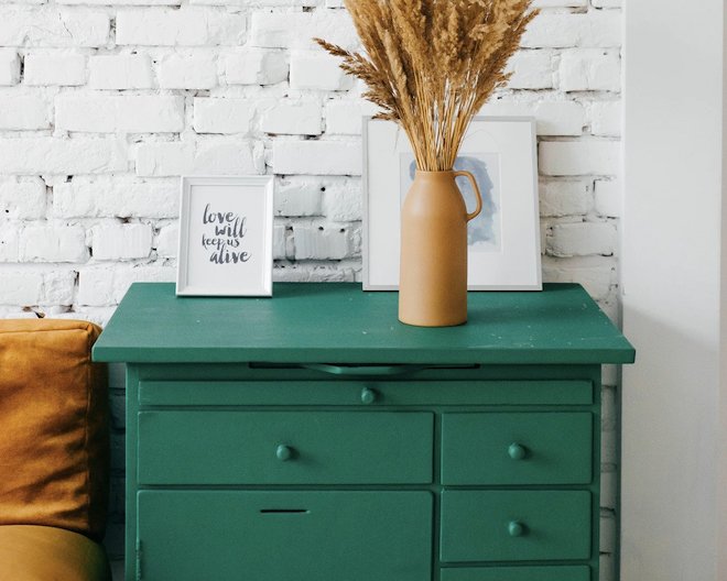 pot with plants and frames on a drawer